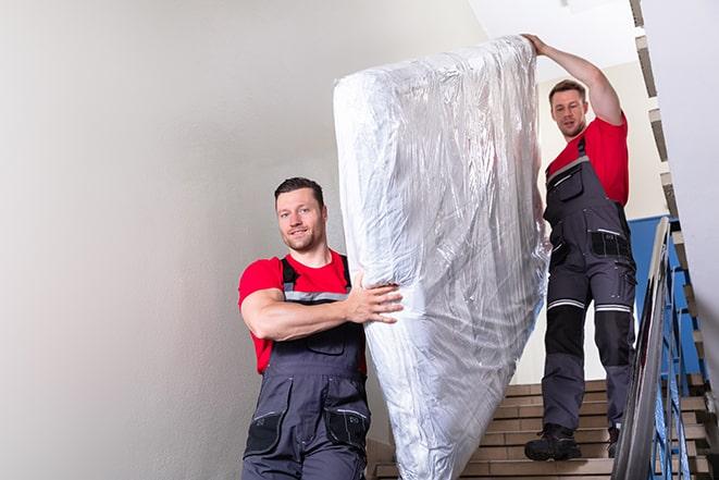 two workers lifting a box spring out of a bedroom in Alhambra CA